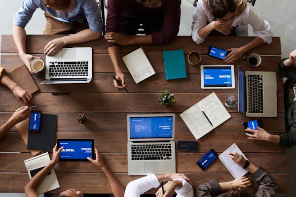 A business environment showcasing professionals using Claude AI vs ChatGPT for workplace productivity.