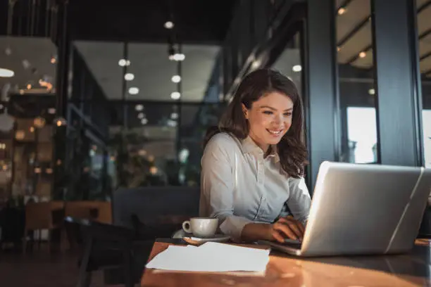 A notebook, coffee, and laptop on a desk, representing a productive work or study environment.